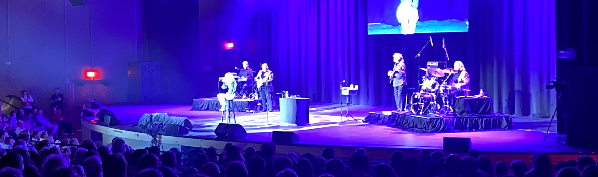 signer on stage in chair washed out by the lights Wilmington